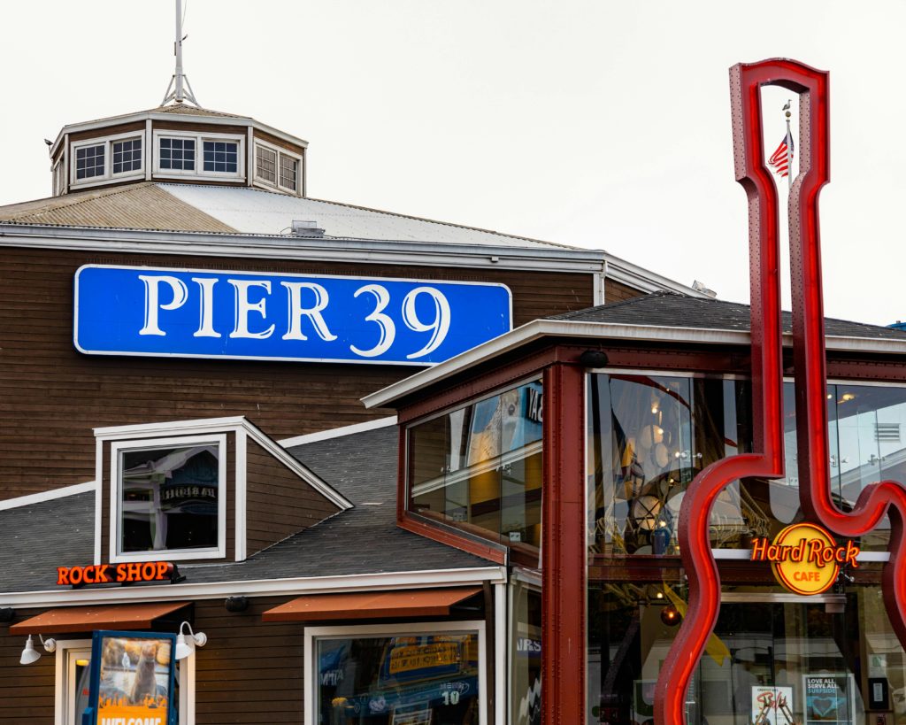 Vibrant photo of Pier 39 and Hard Rock Café's iconic guitar sign in San Francisco.
