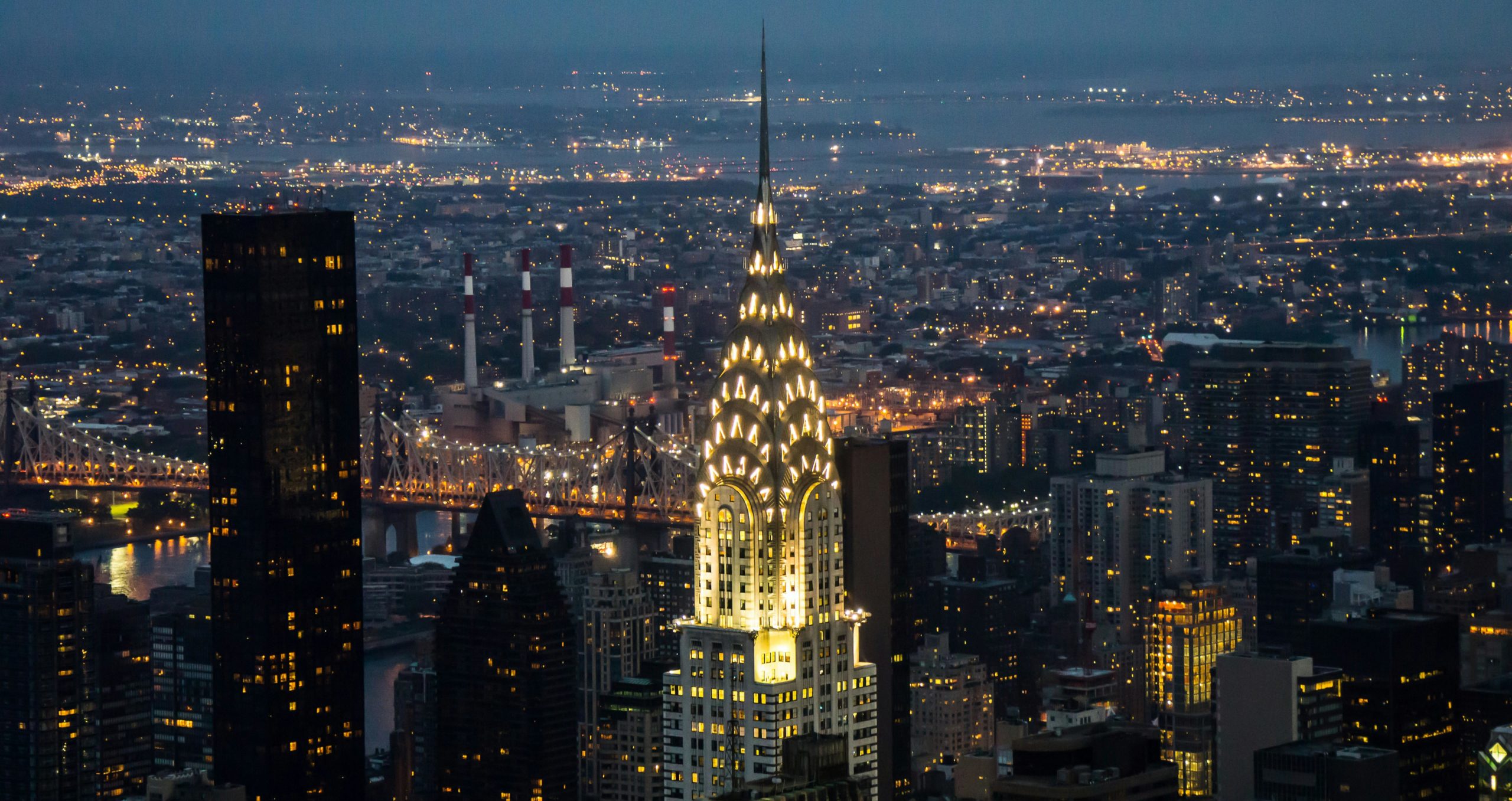 Stunning evening view of the illuminated Chrysler Building in New York City with cityscape backdrop.