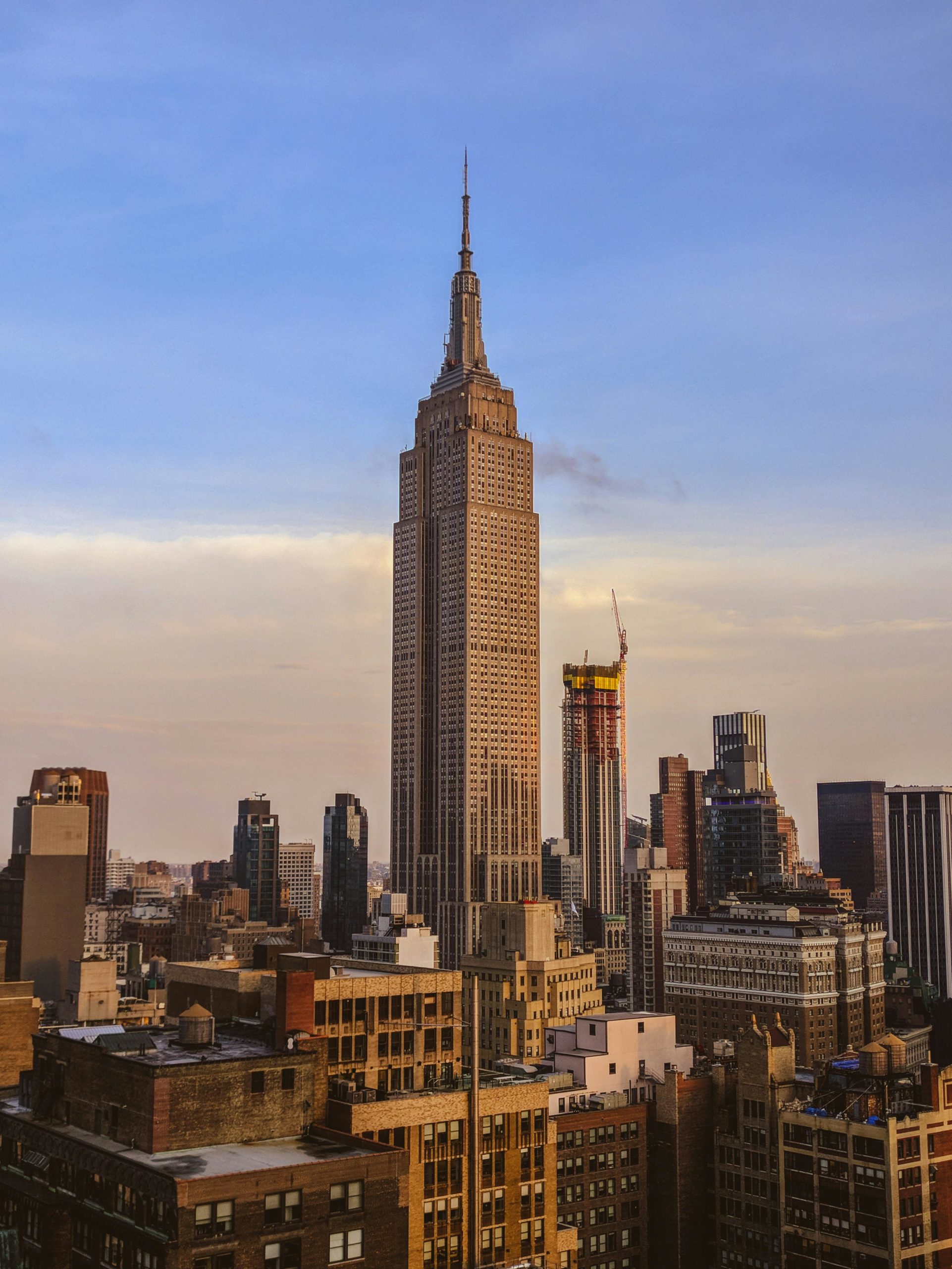 A stunning view of the Empire State Building amidst New York City's urban skyline at sunset.