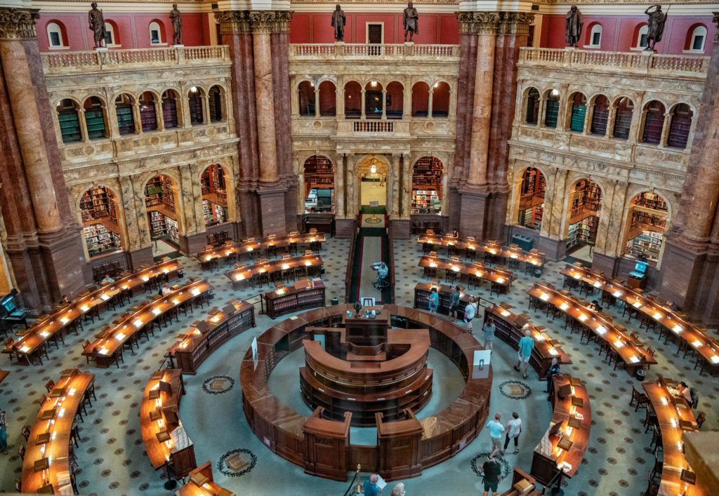 Aerial view of the historic Library of Congress reading room with people and beautiful architecture.