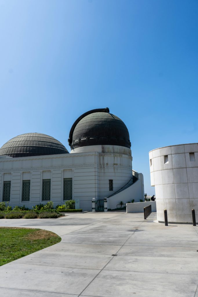 View of Griffith Observatory's domes against a clear blue sky, a landmark in Los Angeles.