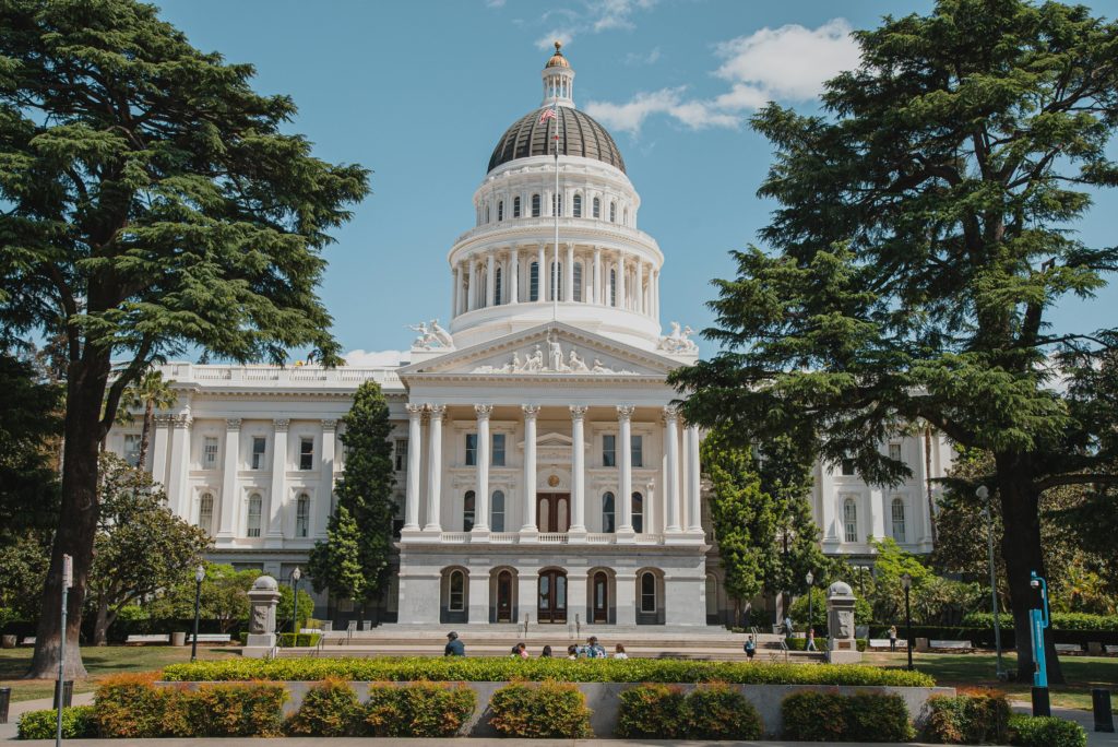 Majestic view of a historical capitol building surrounded by lush greenery.