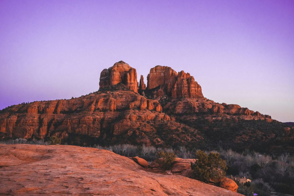 Dramatic view of Cathedral Rock in Sedona, AZ, with vibrant sunset hues.