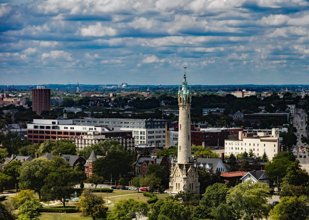 Aerial view of Milwaukee skyline featuring the historic North Point Water Tower under a cloudy sky.